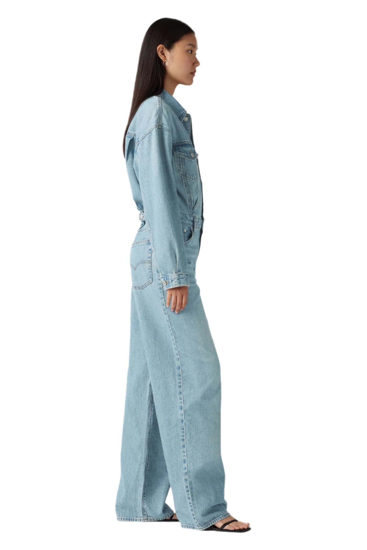 Person wearing a light blue denim outfit on a plain background