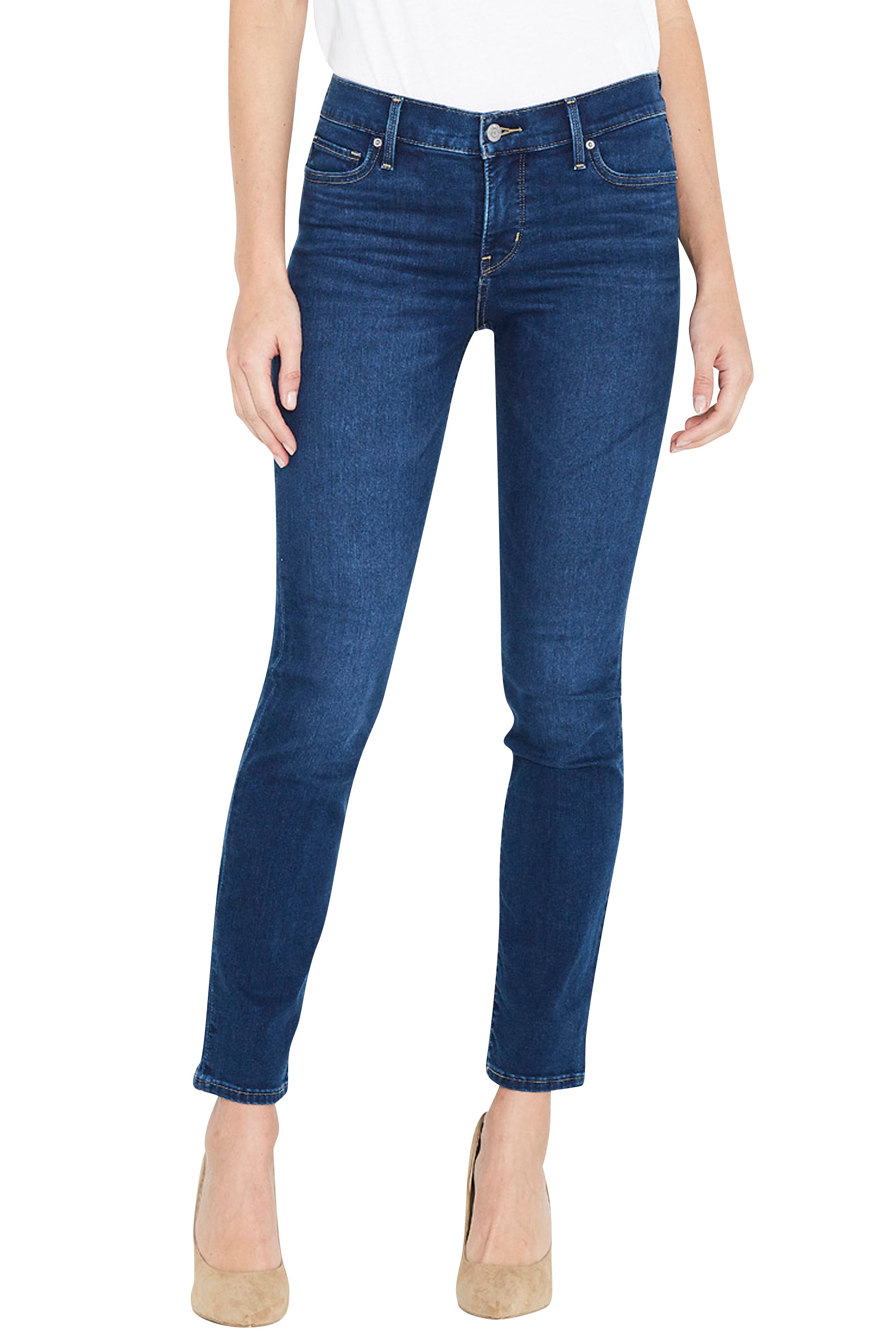 A model wearing dark blue skinny jeans with a white top and beige high heels, shown from the waist down against a plain white background.