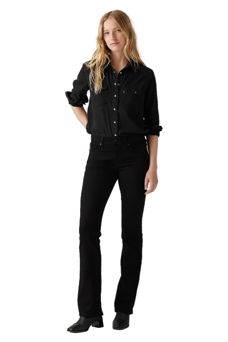 Woman wearing a black shirt and black pants on a gray background