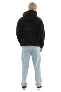 Person wearing a black hoodie and light blue jeans on a plain background