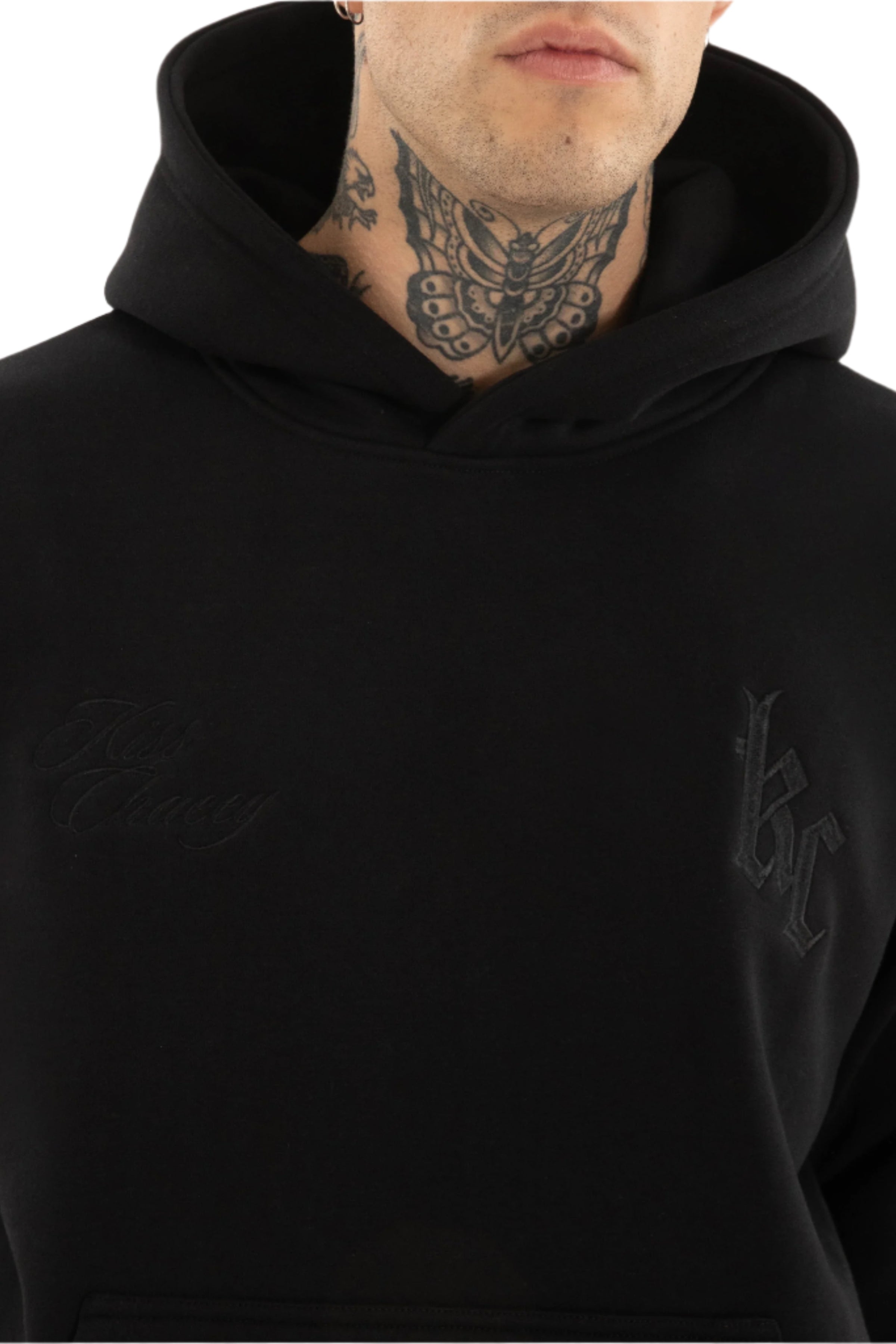 Person wearing a black hoodie with visible branding on a plain background