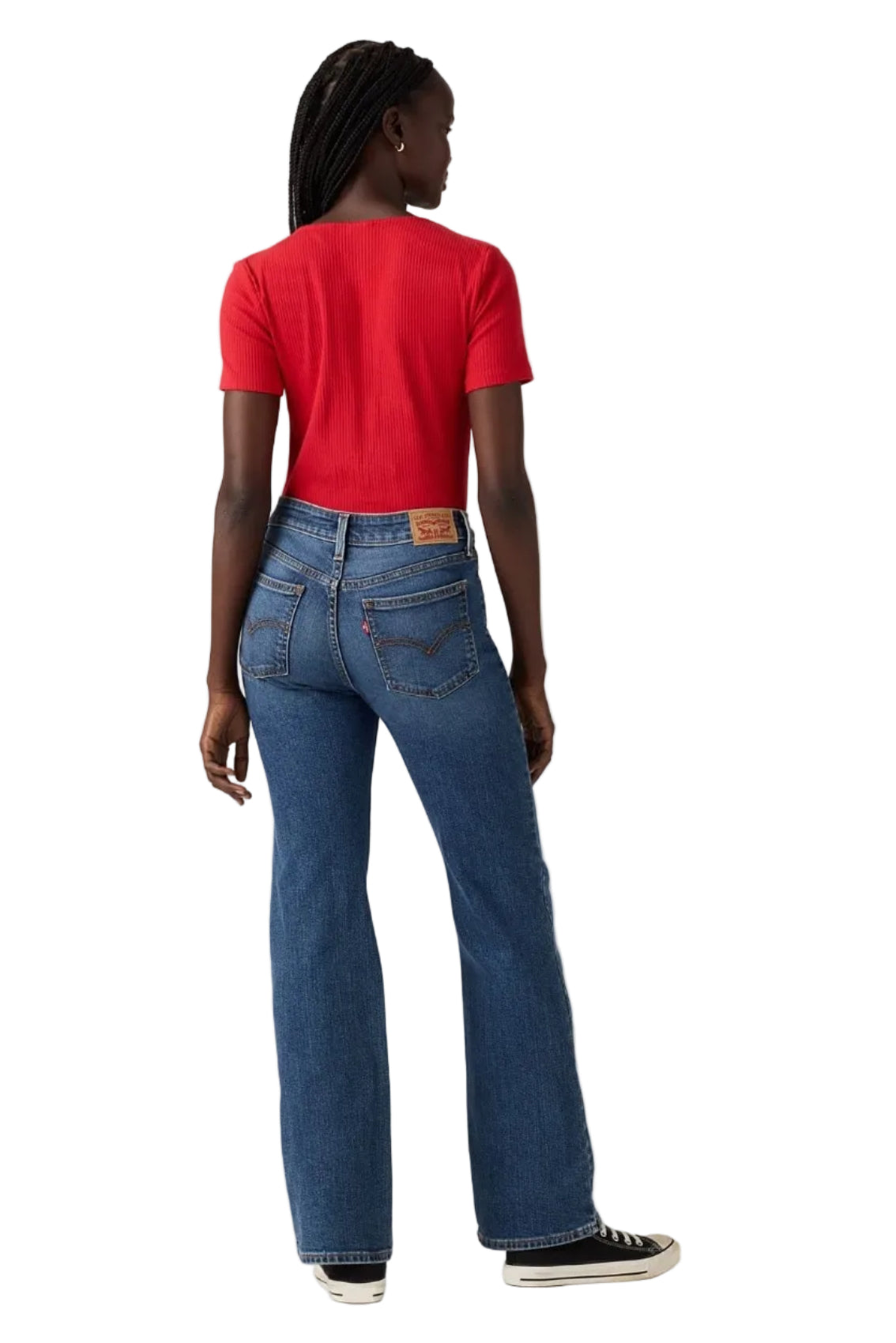 Person wearing a red t-shirt and blue jeans on a plain background