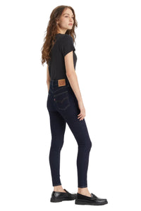 Woman wearing dark blue jeans and a black shirt on a white background