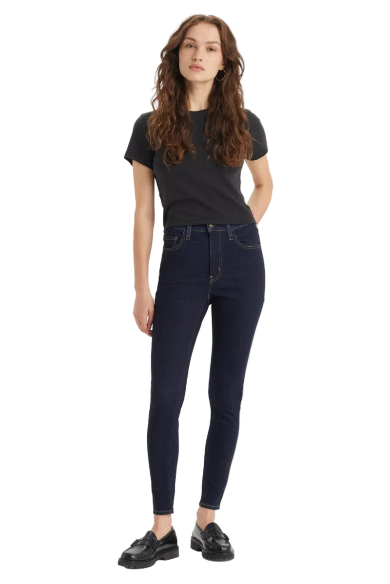 Woman wearing dark blue jeans and a black t-shirt on a white background