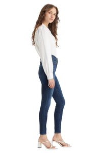 Woman wearing a white blouse and blue jeans on a white background