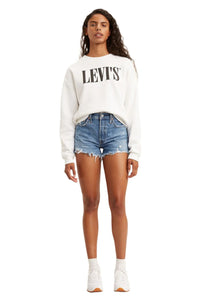 A woman standing straight facing forward wearing Levi's 501 high rise original fit denim shorts with a raw-cut frayed hem and traditional 5-pocket design.