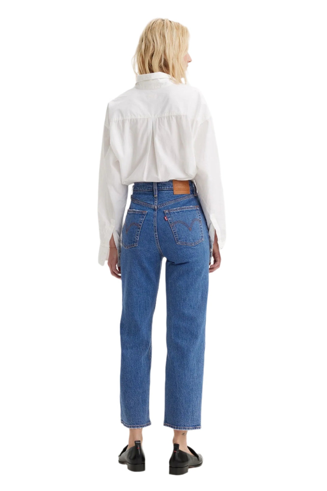 Person wearing blue jeans and a white shirt from the back.