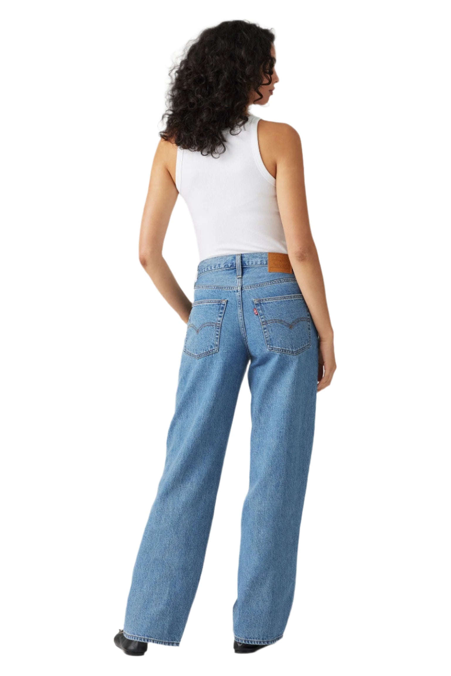 Person wearing blue jeans and a white top from the back.