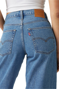 Back view of blue jeans with a brown leather patch.