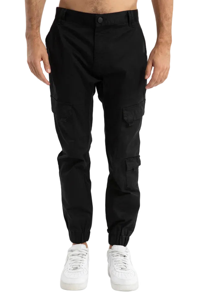 Person wearing black cargo pants on a light gray background