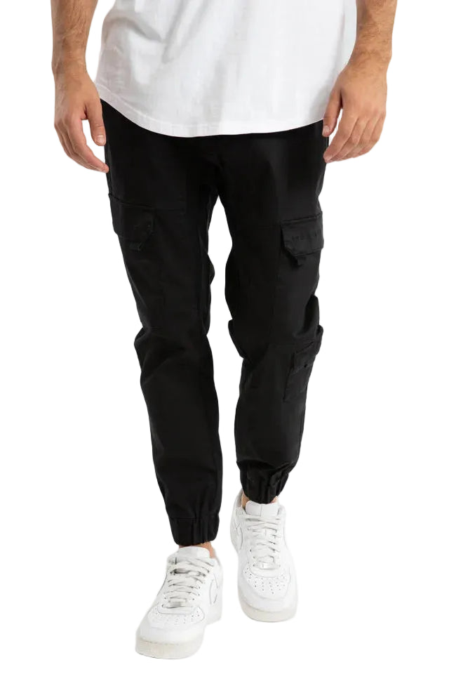 Person wearing black cargo pants and white sneakers on a light gray background