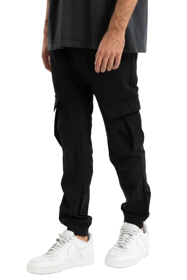 Person wearing black cargo pants and white sneakers on a white background
