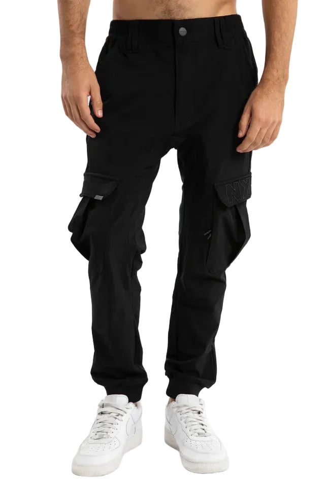 Person wearing black cargo pants on a light gray background