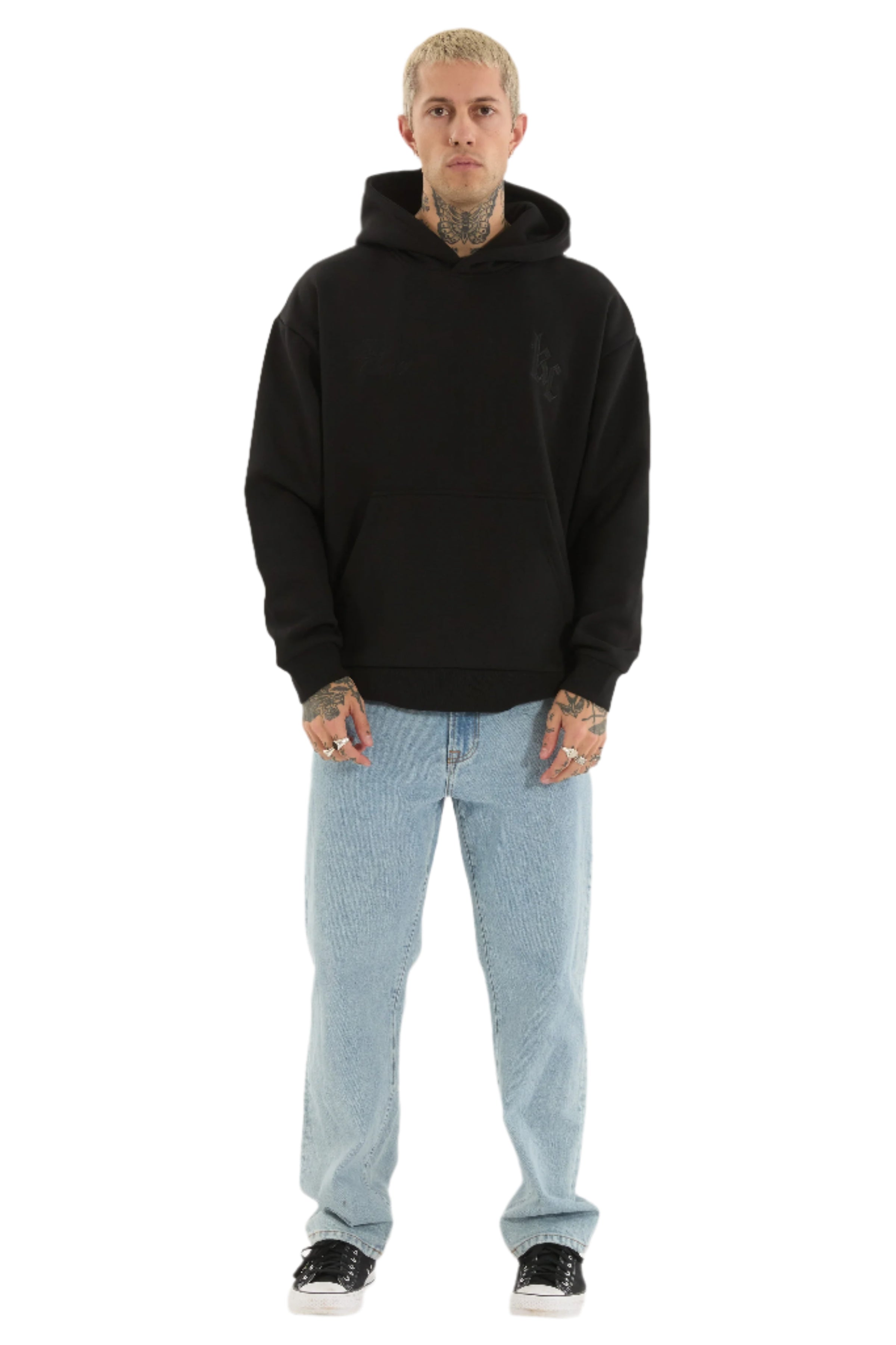 Person wearing a black hoodie and light blue jeans on a white background