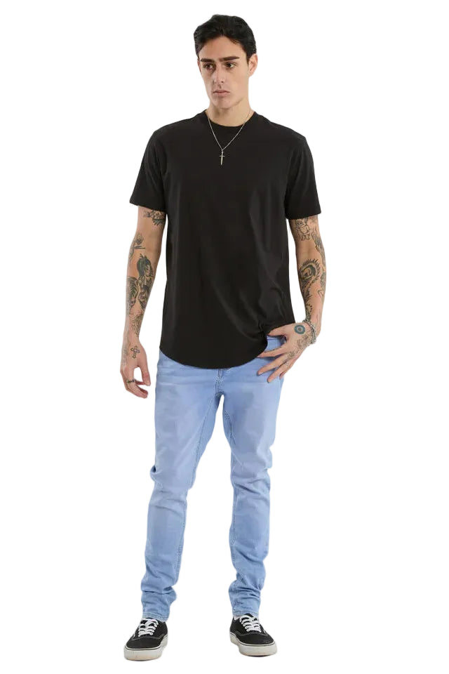 Man wearing a black t-shirt and light blue jeans on a white background