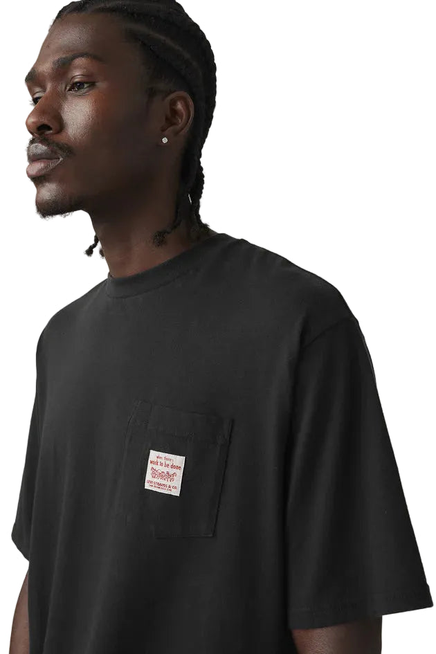 Man wearing a black t-shirt with a small label on a plain background