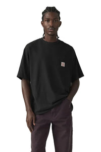 Person wearing a black t-shirt with a small logo on a plain background