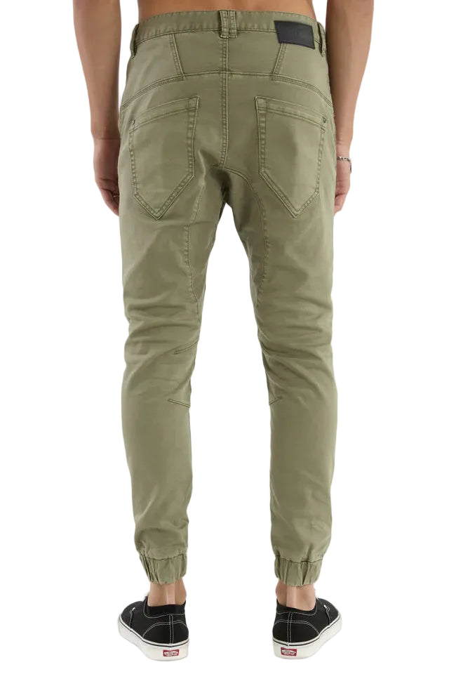 Person wearing olive green jogger pants on a white background