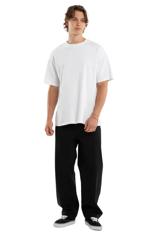 Person wearing a white t-shirt and black pants on a plain background