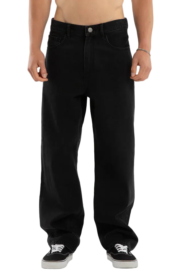 Person wearing black jeans on a plain background