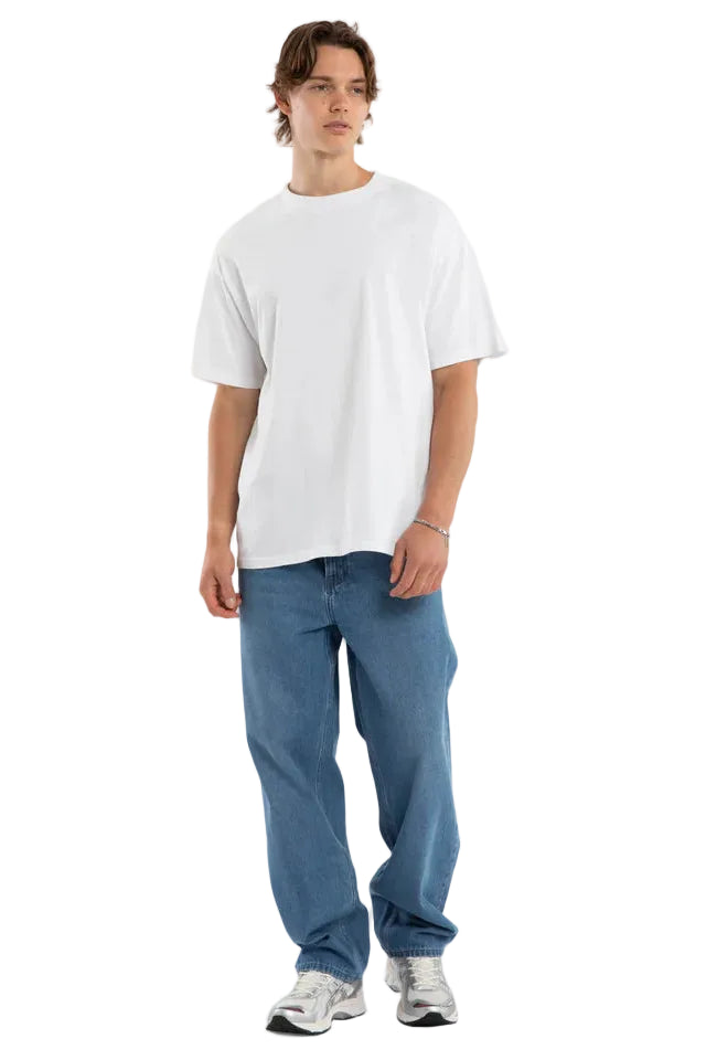 Person wearing a white t-shirt and blue jeans on a plain background