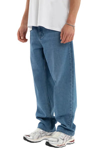 Person wearing blue jeans and a white shirt on a plain background