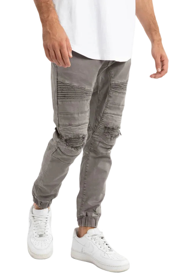 Person wearing gray cargo pants and white sneakers on a white background