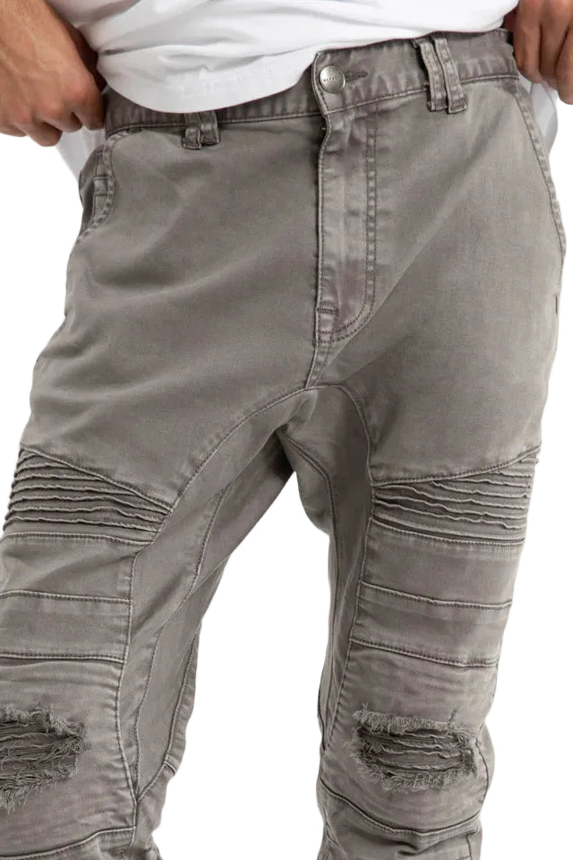 Gray distressed jeans worn by a person on a white background