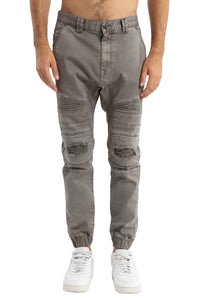 Person wearing gray distressed jogger pants on a white background