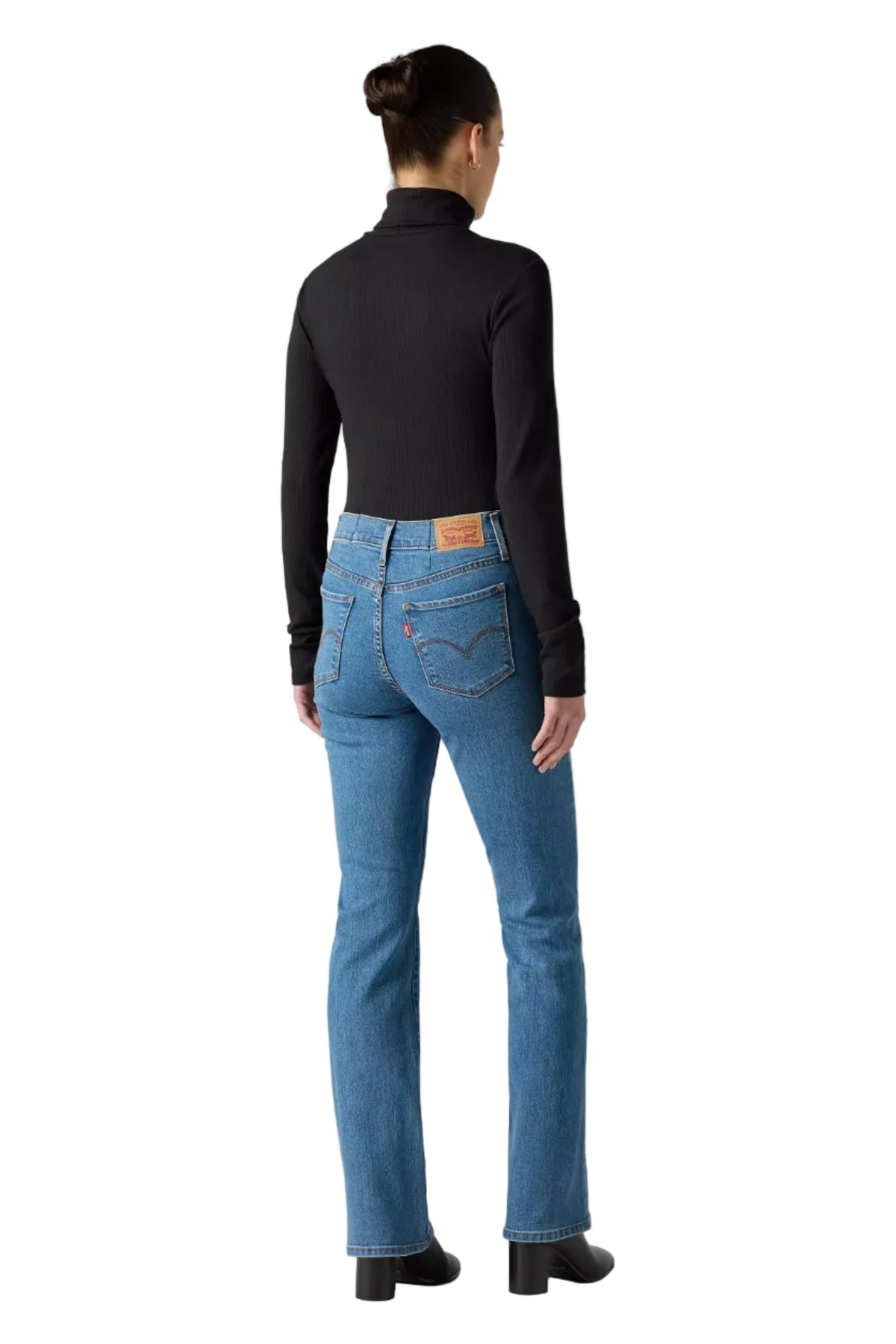 Person wearing blue jeans and a black long-sleeve shirt on a gray background