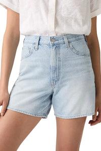 Light blue denim shorts worn by a person on a plain background