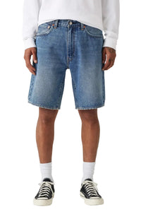 Person wearing blue denim shorts on a white background
