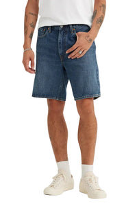Person wearing blue denim shorts on a white background