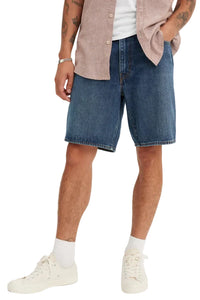 Person wearing blue denim shorts on a white background
