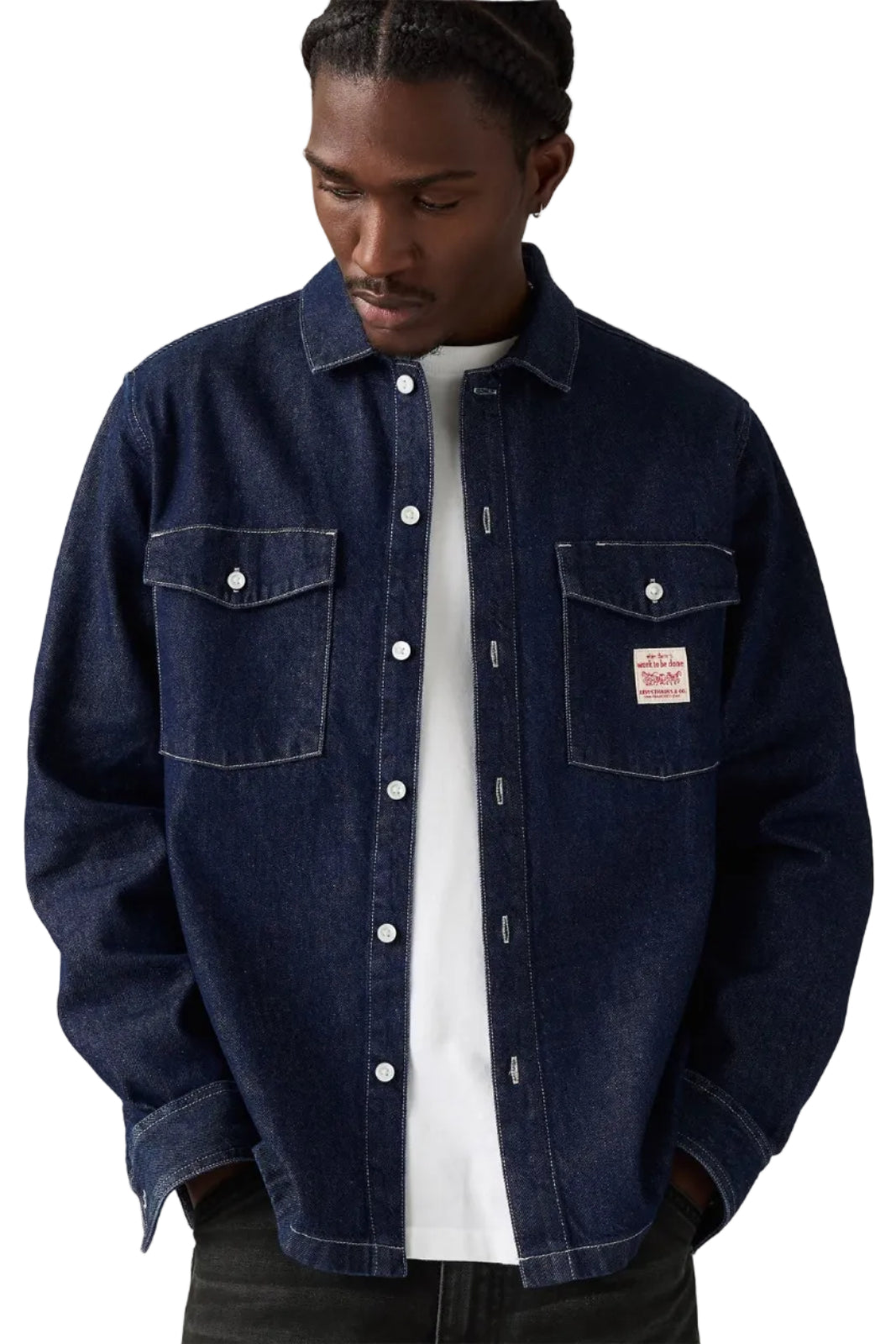 Man wearing a dark blue denim jacket on a plain background
