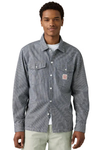 Man wearing a striped shirt with a brand logo on a plain background