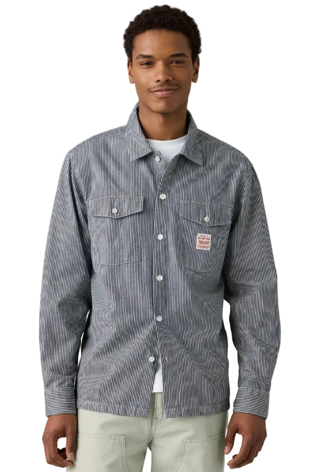 Man wearing a striped shirt with a brand logo on a plain background