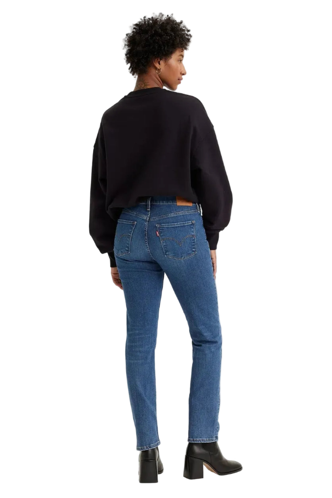 Person wearing blue jeans and a black sweater on a white background