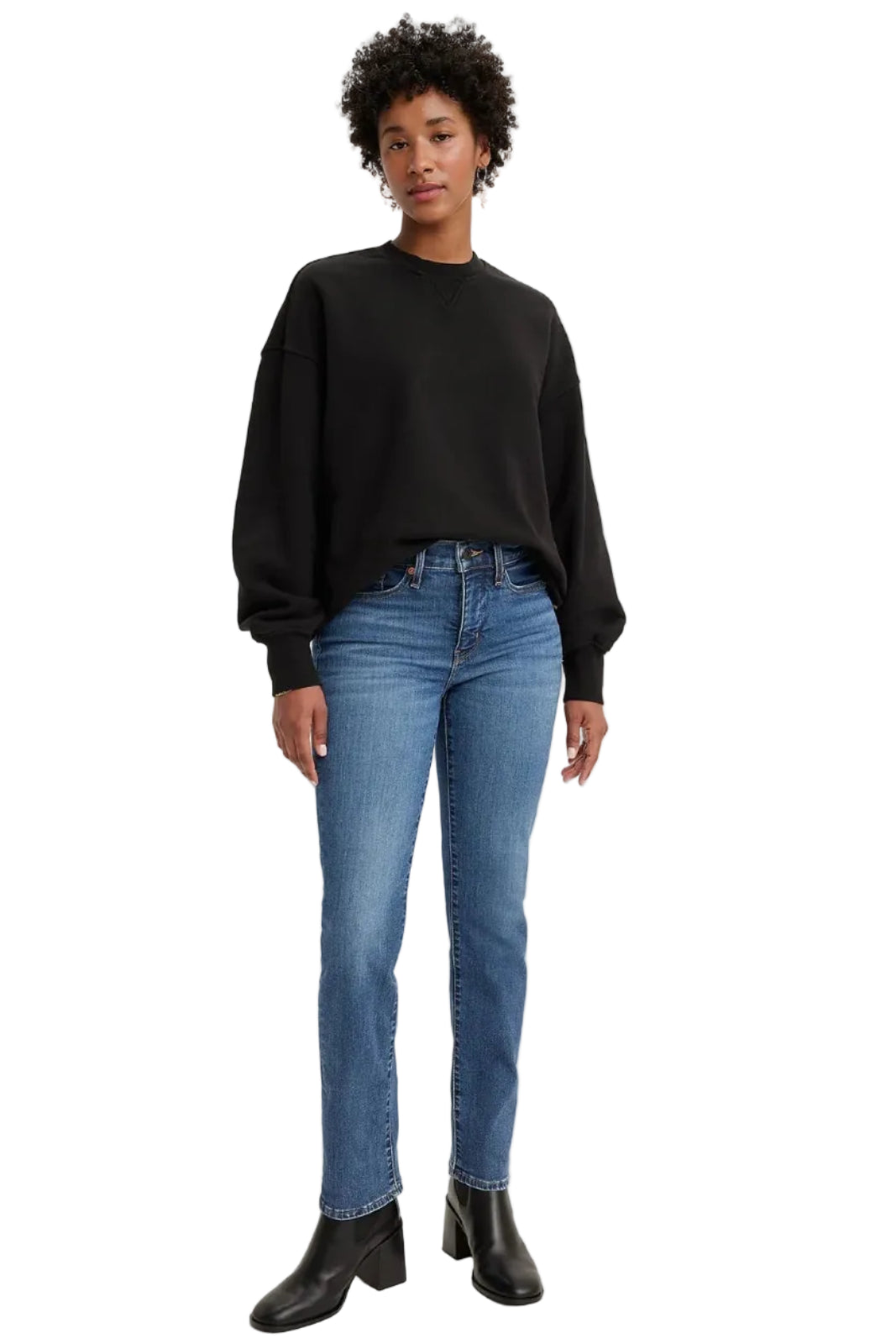 Person wearing a black sweater and blue jeans on a white background
