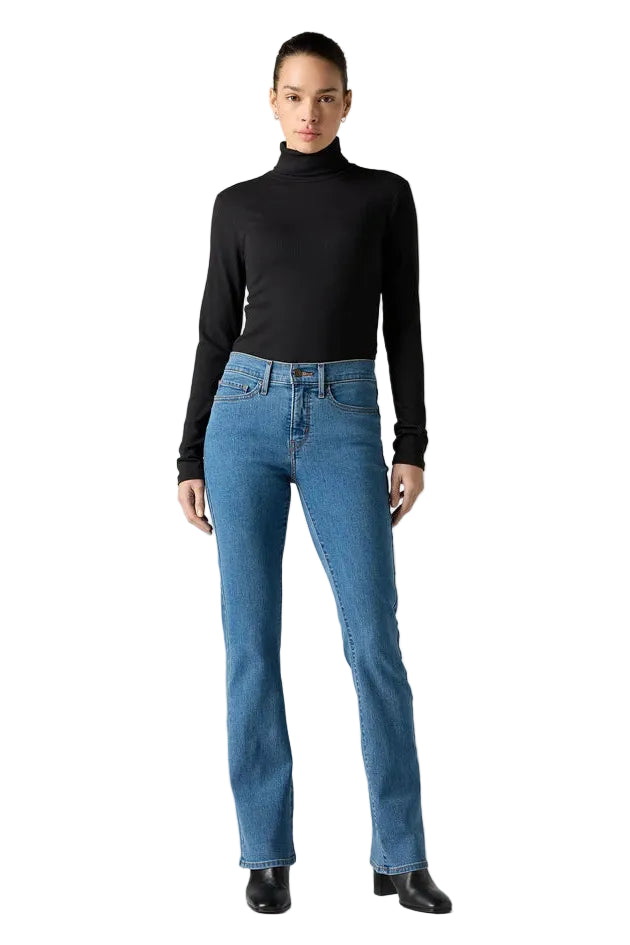 Person wearing blue jeans and a black turtleneck on a gray background