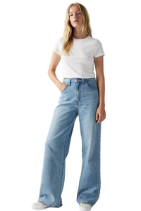 Person wearing light blue jeans and a white t-shirt on a plain background