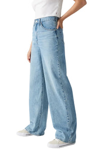 Light blue jeans worn by a person on a plain background