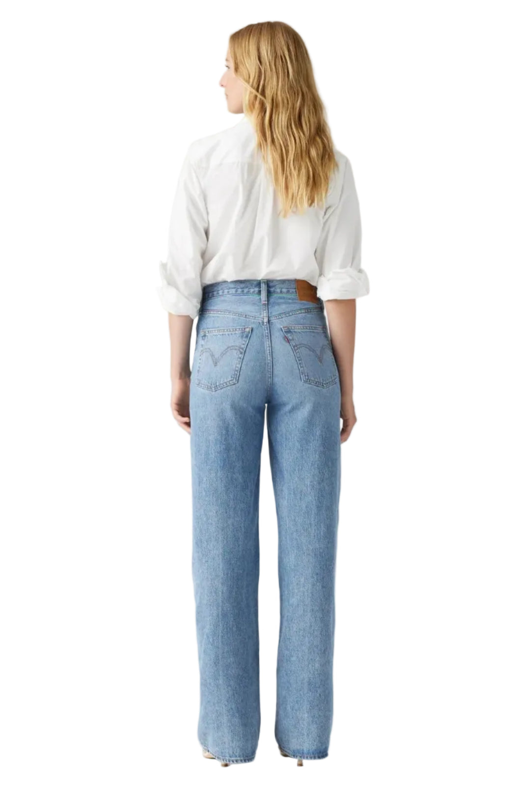Person wearing light blue jeans and a white shirt on a plain background