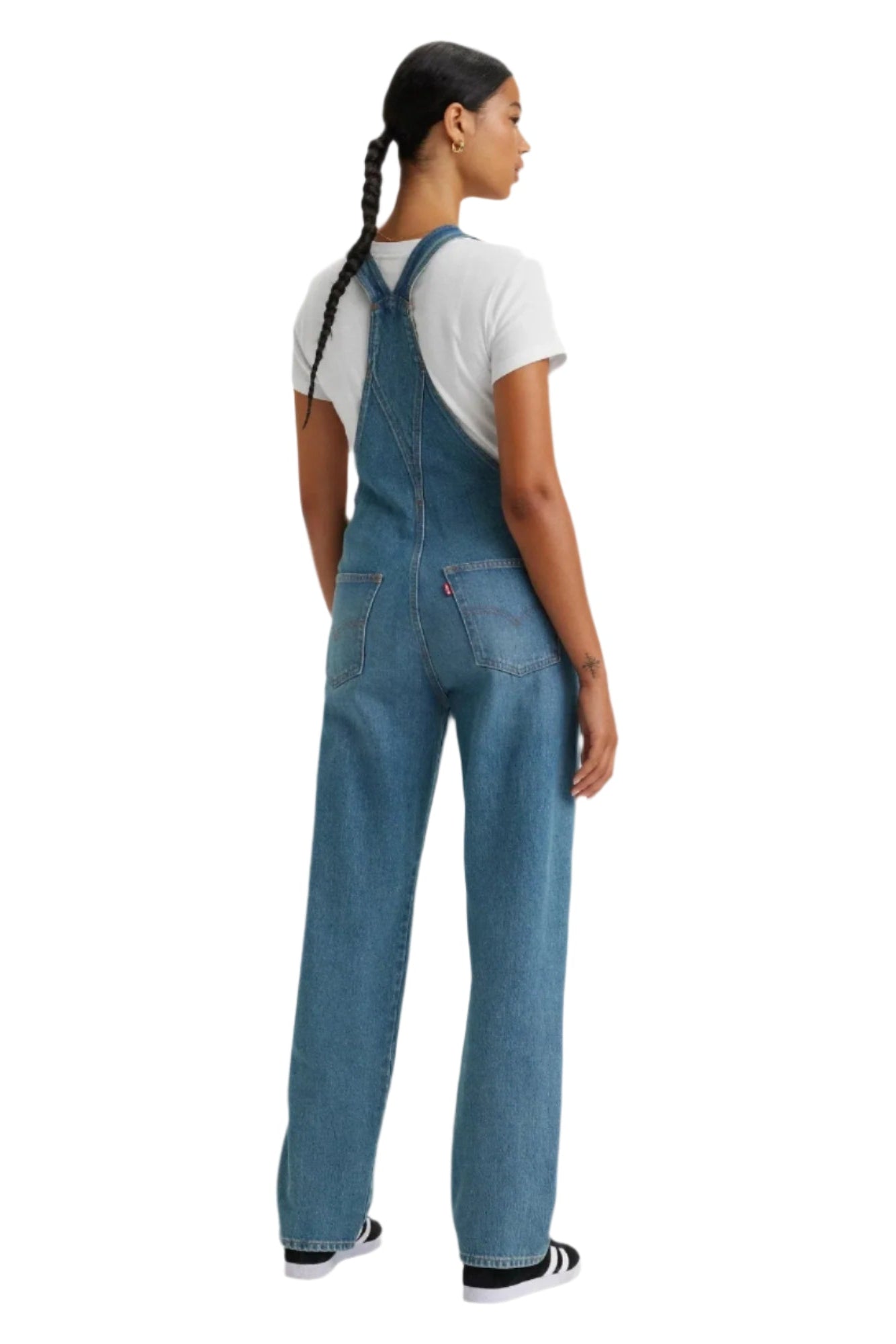 Person wearing blue denim overalls on a white background