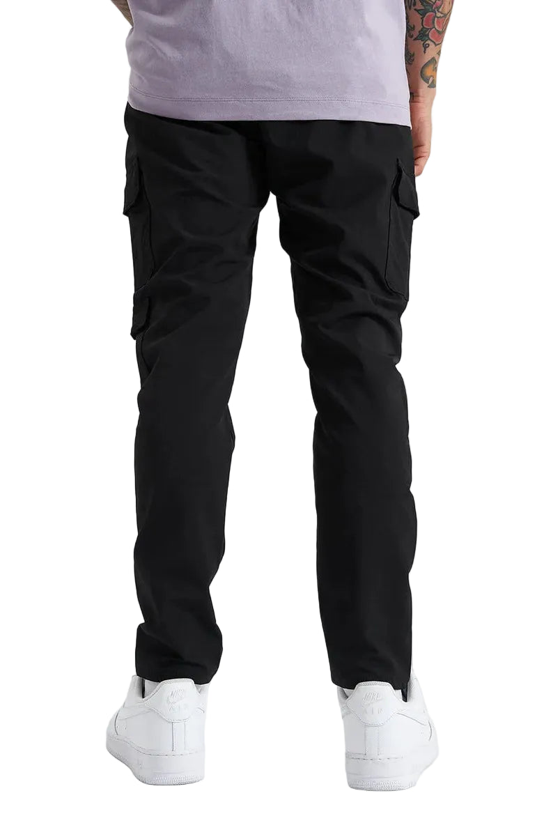Person wearing black cargo pants and white sneakers on a white background