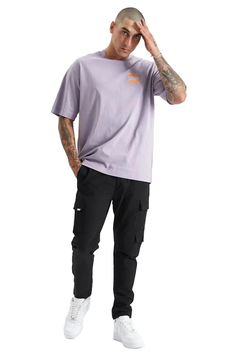 Man wearing a light purple t-shirt and black cargo pants on a white background