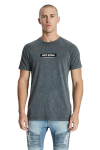 A male model wearing a gray NXP branded t-shirt with a cape back detail, paired with blue distressed jeans.